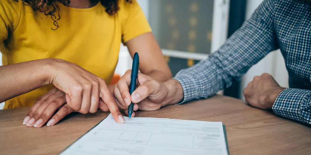 Close up of two people discussing contract documents