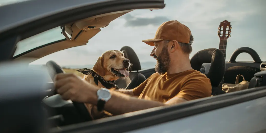Two people in a convertible on the road