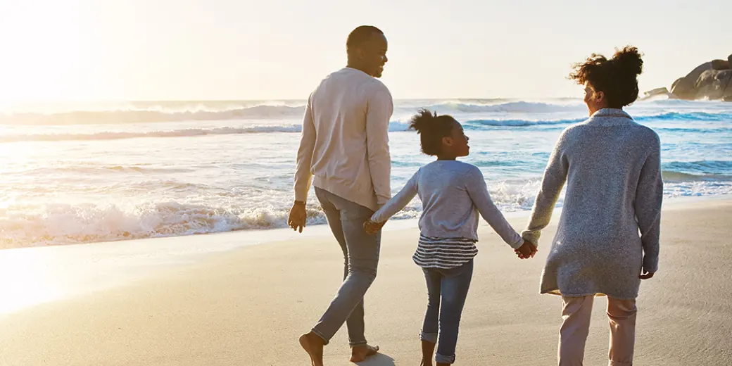 Family of 3 walking on the beach